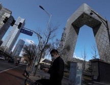 Un hombre con tapabocas camina cerca del edificio de la Televisión Central de China (CCTV) en el distrito central de negocios (CBD) en Beijing, China. EFE/W. Hong