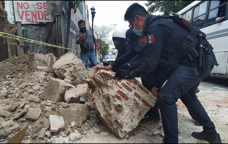 Policías y elementos de Protección Civil levantan parte de una barda derrumbada en la ciudad de Oaxaca. EFE/D. Ricardez