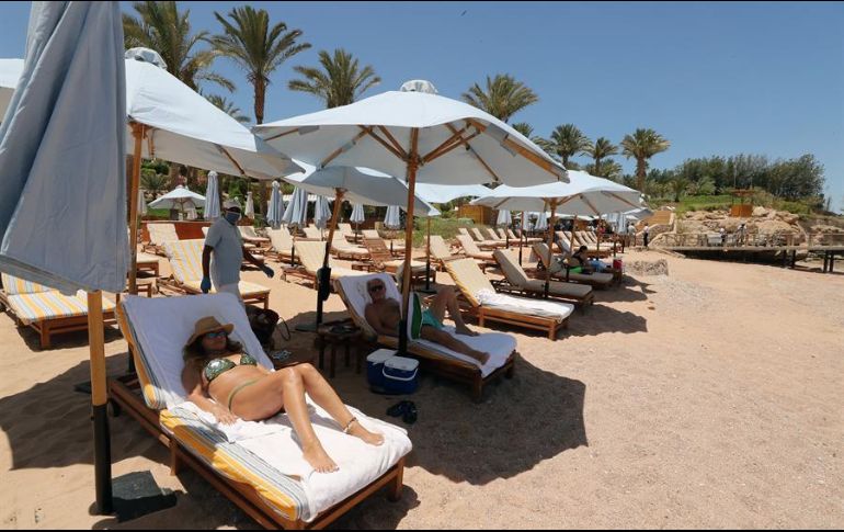 Con las debidas medidas de distanciamiento, turistas toman el sol en un resort de Sharm el-Sheikh, en Egipto, región que se caracteriza por sus playas y balnearios. EFE/K. Elfiqi