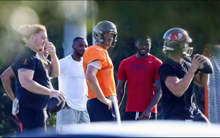 Tom Brady (naranja) fue captado entrenando junto con sus compañeros, desobedeciendo los protocolos establecidos por la NFL. AP