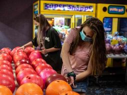 Jóvenes recogen bolas limpias en un boliche de Westgate Lanes en Austin, Texas. Los comercios no esenciales cerrarán sus puertas nuevamente ante el repunte de infecciones. AFP/S. Flores