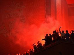 Los aficionados del Liverpool salieron este jueves a la calle a celebrar el título de campeones de la Premier League que han conseguido por primera vez en los últimos treinta años. AFP / O. Scarff