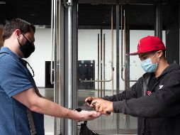 Un trabajador de un supermercado aplica desinfectante a un cliente hoy en la ciudad de Nueva York. El estado del mismo nombre, que fue epicentro de la pandemia, registra ahora un descenso de los casos. AP/M. Lennihan