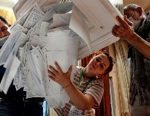 Integrantes de una comisión electoral vacían una urna en una casilla electoral en Moscú. AFP/A. Nemenov