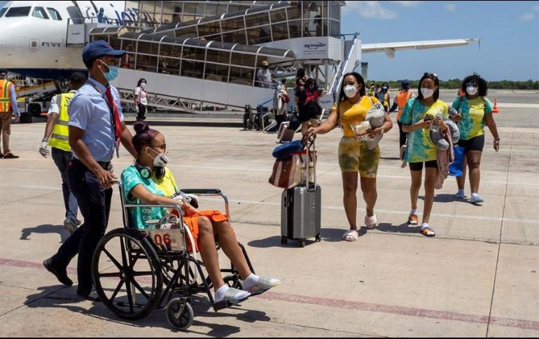Pasajeros descienden de un avión de la aerolínea Jet Blue procedente de Nueva York, siendo este el primer vuelo internacional en llegar este miércoles a República Dominicana. EFE/F. Spotorno