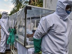 Trabajadores de la salud trasladan a un hospital a un paciente de COVID-19 en Puerto Carreno, Colombia. AFP/T. De Nevo