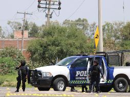 Policías estatales vigilan las cercanías del sitio donde sus compañeros fueron ultimados. EFE