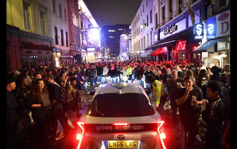 El barrio londinense de Soho se vio especialmente abarrotado. Un vehículo intenta pasar entre la multitud. AFP/J. Tallis