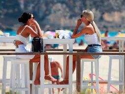 Dos turistas en una terraza disfrutan de un soleado día en la playa de Los Lances, en Tarifa, España. EFE/A. Carrasco