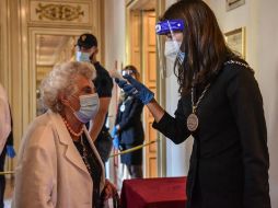 Una empleada del Teatro alla Scala, en Milán, mide la temperatura de una asistente a uno de los espectáculos. EFE/M. Corner