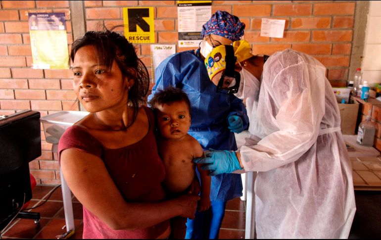 Trabajadores de la salud revisan el estado de salud de un bebé del pueblo Yukpa, en la frontera de Colombia con Venezuela. AFP/S. Mendoza