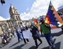 Docentes y organizaciones obreras muestran pancartas y ondean banderas este martes durante una protesta en La Paz. EFE