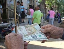 Un hombre muestra un peso convertible cubano y un dólar estadounidense. EFE/ARCHIVO