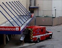 Un auxiliar de enfermería coloca una camilla vacía en la ambulancia frente al centro de emergencias del Hospital Metodista de Houston. EFE/A. Sprecher