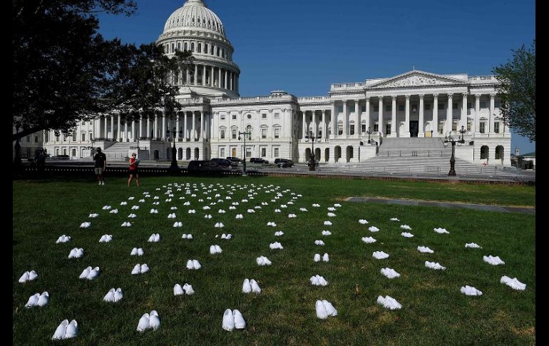 Los zapatos de plástico blanco fueron dispuestos en el césped frente al edificio del Congreso estadounidense. AFP/O. Douliery