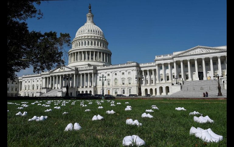 Los zapatos de plástico blanco fueron dispuestos en el césped frente al edificio del Congreso estadounidense. AFP/O. Douliery