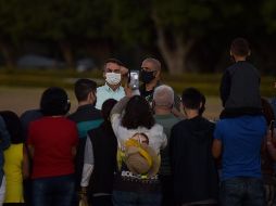 Bolsonaro conversó con algunos partidarios en los jardines de su residencia oficial en Brasilia.  EFE/A. Borges