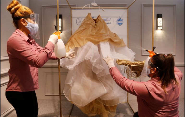 Trabajadoras de la tienda Ragazza desinfectan un vestido de novia. EFE/F. Guasco