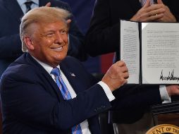 Donald Trump muestra el documento firmado en un acto en Midland, Texas. AFP/N. Kamm