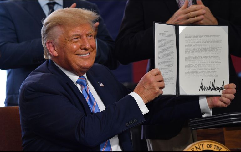 Donald Trump muestra el documento firmado en un acto en Midland, Texas. AFP/N. Kamm