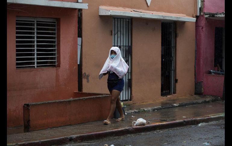 Una mujer se protege de la lluvia este jueves en Santo Domingo. EFE/O. Barría