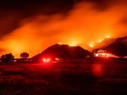 El incendio estaba ayer cerca de un área residencia en Banning, California. AFP/J. Edelson