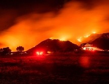 El incendio estaba ayer cerca de un área residencia en Banning, California. AFP/J. Edelson