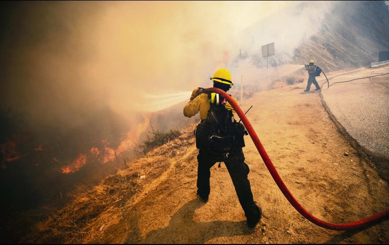 LUCHA. Bomberos intentan sofocar las llamas desde el viernes pasado. EFE