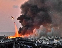 Un helicóptero combate las llamas tras una explosión. AFP