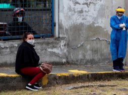 Una mujer con síntomas de COVID espera a ser atendida en una carpa de triaje para realizarle pruebas de sangre, en Quito, Ecuador. EFE/José Jácome/Archivo