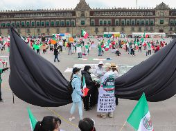 Manifestantes colocan un crespón en conmemoración por las víctimas de la violencia y fallecidos por el COVID-19 durante la protesta  en el Zócalo. EFE/J. Pazos