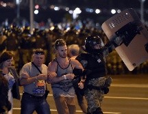 Policías antimotines detienen a manifestantes en Minsk. AFP/S. Gapon