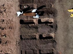 Trabajadores en el entierro de un área del panteón acondicionada para dar cabida al aumento de fallecidos por la pandemia. AFP/E. Lasalvia