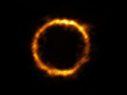 SPT0418-47 luce como un hermoso anillo de luz sobre fondo negro. AFP /