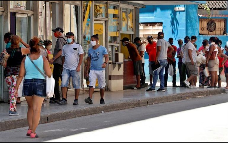 Personas con tapabocas hacen fila para comprar en una cafetería ubicada en La Habana, Cuba. EFE/E. Mastrascusa