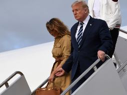 Al bajar del avión presidencial, Donald Trump intentó tomar de la mano a su esposa, pero ella no accedió. AP / S. Walsh