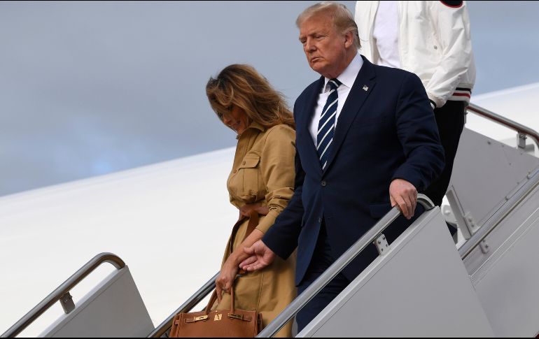 Al bajar del avión presidencial, Donald Trump intentó tomar de la mano a su esposa, pero ella no accedió. AP / S. Walsh