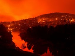 La televisora local mostró imágenes de viviendas en llamas y una lluvia de cenizas en una zona rural cerca de la Carretera Interestatal 80, mientras el incendio parecía acercarse a la zona poblada. AP / N. Berger