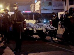 Oficiales vigilan junto a cuerpos afuera de la discoteca en Lima. AP/D. Vertiz