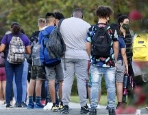 En medio de la pandemia, escuelas en el condado de Hillsborough, en Florida, dan la opción de que los estudiantes tomen clases en las escuelas. Estudiantes hacen fila hoy para que les tomen la temperatura antes de entrar a una preparatoria. AFP/ O. Jones
