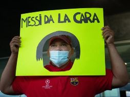 Un seguidor del FC Barcelona muestra una pancarta a Jorge Messi, padre y agente de Lionel Messi, a su llegada este miércoles a la terminal de vuelos privados del Aeropuerto de Barcelona. EFE/E. Fontcuberta