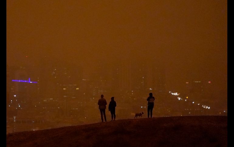 Personas observan el cielo oscurecido por el humo y la niebla desde Kite Hill Open Space. AP/J. Chiu