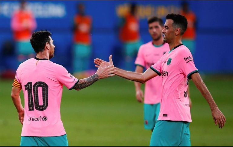 Leo Messi (i) celebra con su compañero Sergi Busquets (d) tras marcar el 2-0 durante el partido de pretemporada ante el Girona FC. EFE/E. Fontcuberta