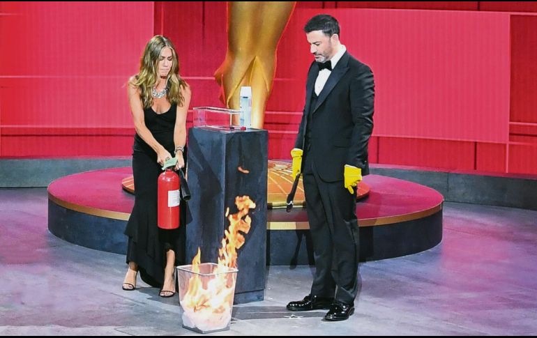 MÁXIMO CUIDADO. En la presentación de la primera terna, el comediante Jimmy Kimmel tomó con guantes la tarjeta, sin embargo tras rociarla con spray sanitizante la depositó en un cesto de basura para prenderle fuego y “matar los virus”. Por supuesto ahí estuvo Jennifer Aniston para apagar el pequeño incendio. AFP