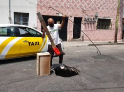 Este lunes, vecinos pusieron un cajón de madera para alertar a los conductores sobre la presencia del agujero. EL INFORMADOR/S. Blanco