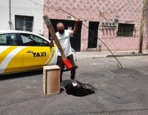 Este lunes, vecinos pusieron un cajón de madera para alertar a los conductores sobre la presencia del agujero. EL INFORMADOR/S. Blanco
