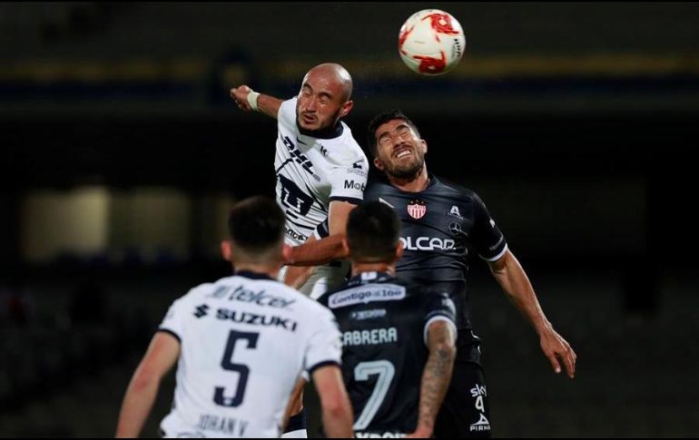 Carlos González (i) de Pumas e Ian González (d) del Necaxa saltan al cabecear el balón este sábado. EFE/J. Núñez