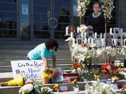 Una mujer deposita flores en un monumento dedicado a Ruth Bader Ginsburg ubicado en la Suprema Corte de EU. EFE/E. García