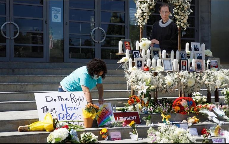 Una mujer deposita flores en un monumento dedicado a Ruth Bader Ginsburg ubicado en la Suprema Corte de EU. EFE/E. García