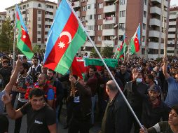 Personas cargan banderas azerbaiyanas en el funeral de un militar presuntamente muerto en combate. AP/A. Karimov